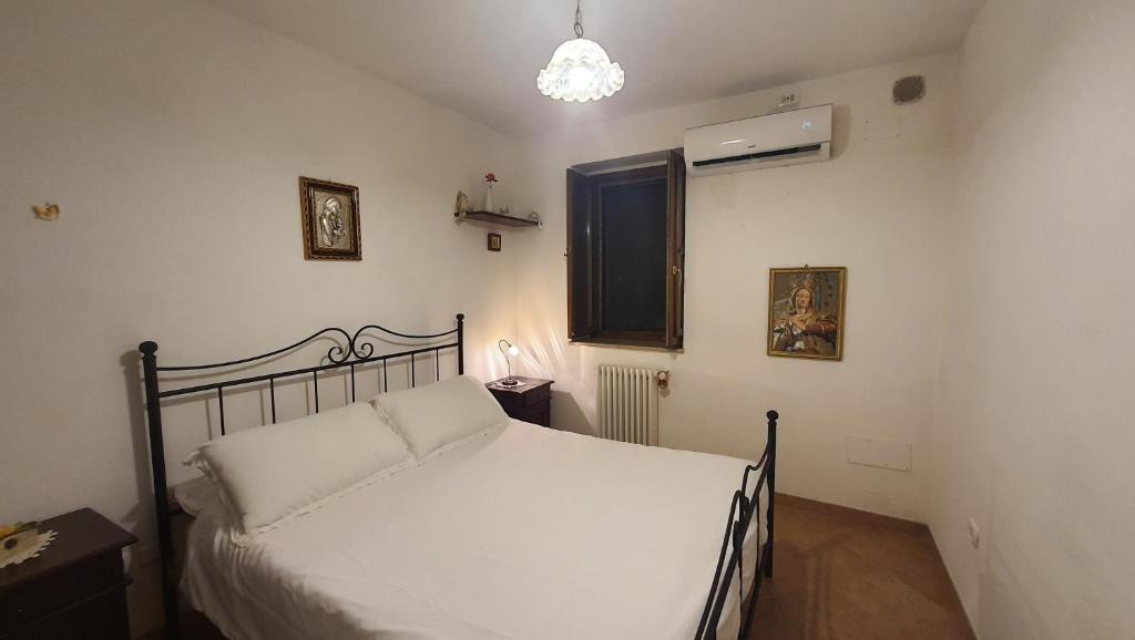 sypialnia z białym łóżkiem i oknem w obiekcie Piccoli Desideri Tra le Singolarità del Molise w mieście Forlì del Sannio