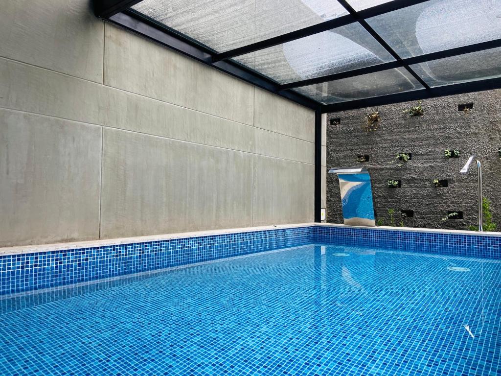a large swimming pool with a large blue tile floor at Wynwood House 100 in Bogotá
