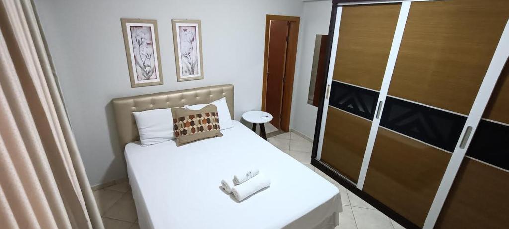 a small bedroom with a bed and a closet at Apart Victoria in Vitória da Conquista