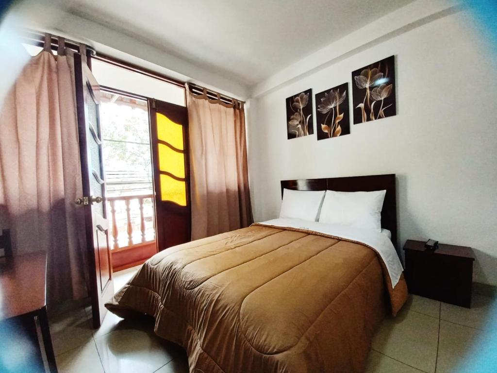 a bedroom with a bed and a large window at TintayaHotel in Chachapoyas