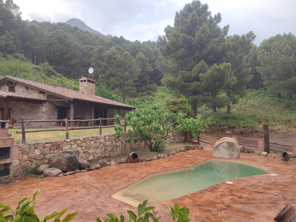 una piccola piscina in un cortile accanto a una casa di Casa Rural Refugio Los Perdigones a El Arenal