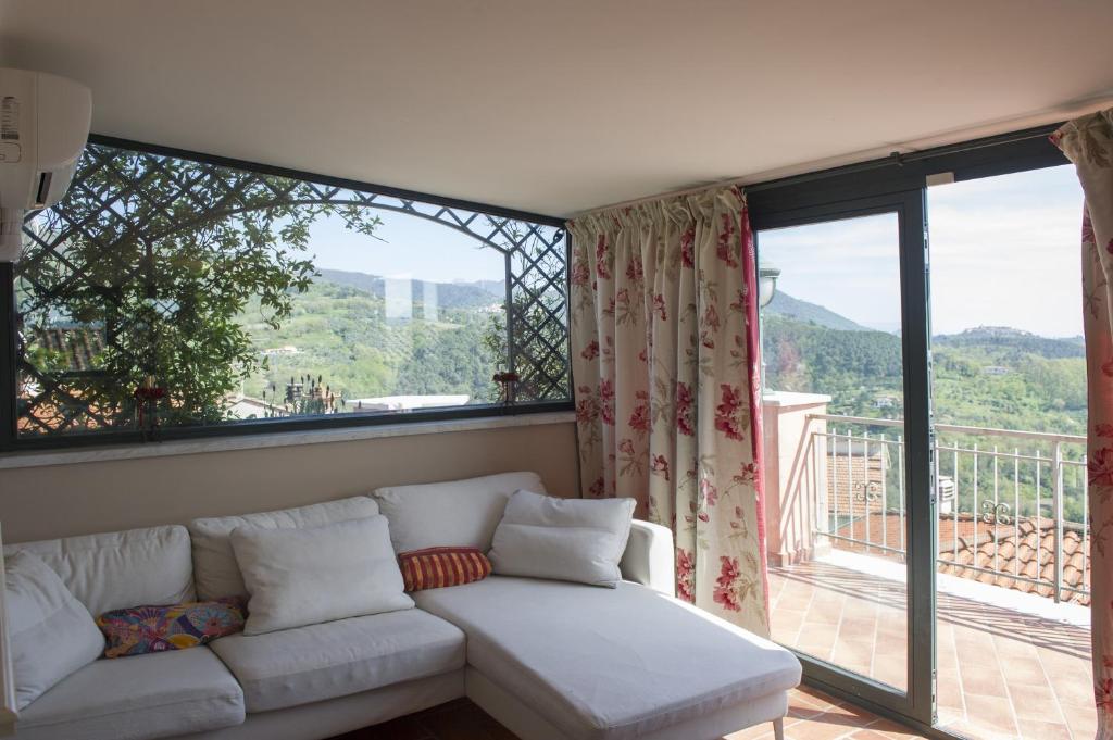 a living room with a couch and a large window at Vita Lumiere in Castelnuovo Magra