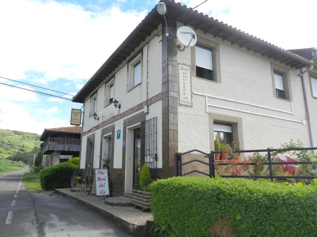 um edifício com um relógio na lateral em Pension Parrilla Casa Vicente em Tineo