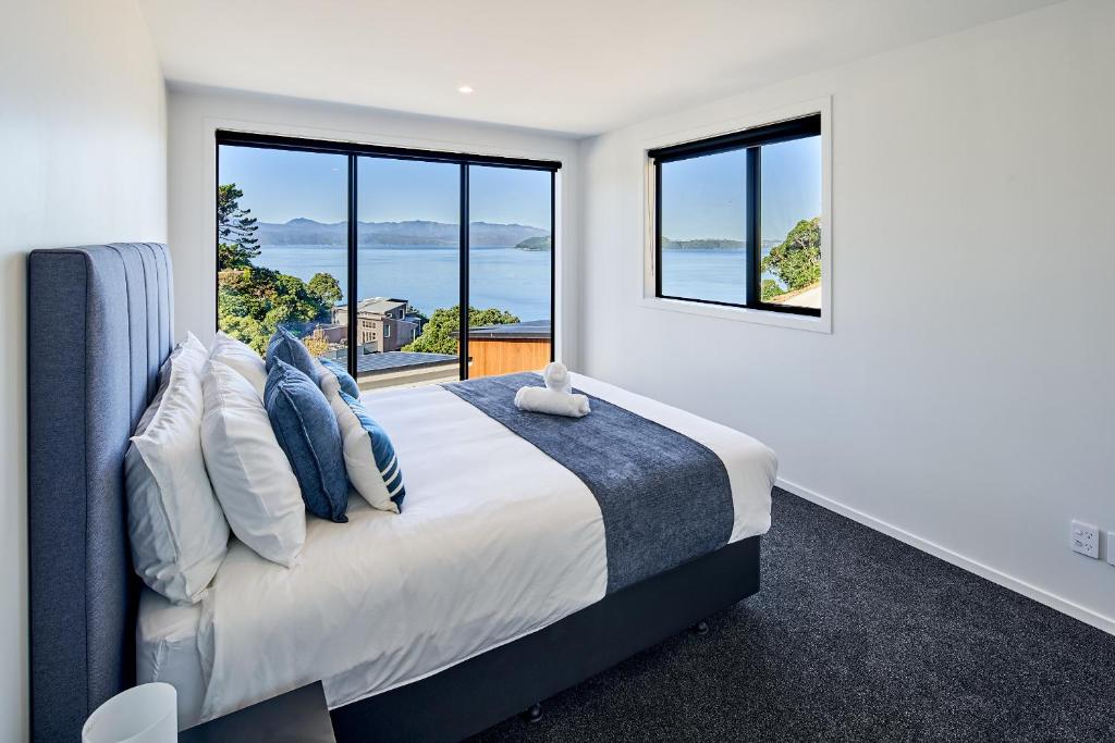 a bedroom with a large bed with a large window at Brand New Townhouse with Ocean Views in Wellington