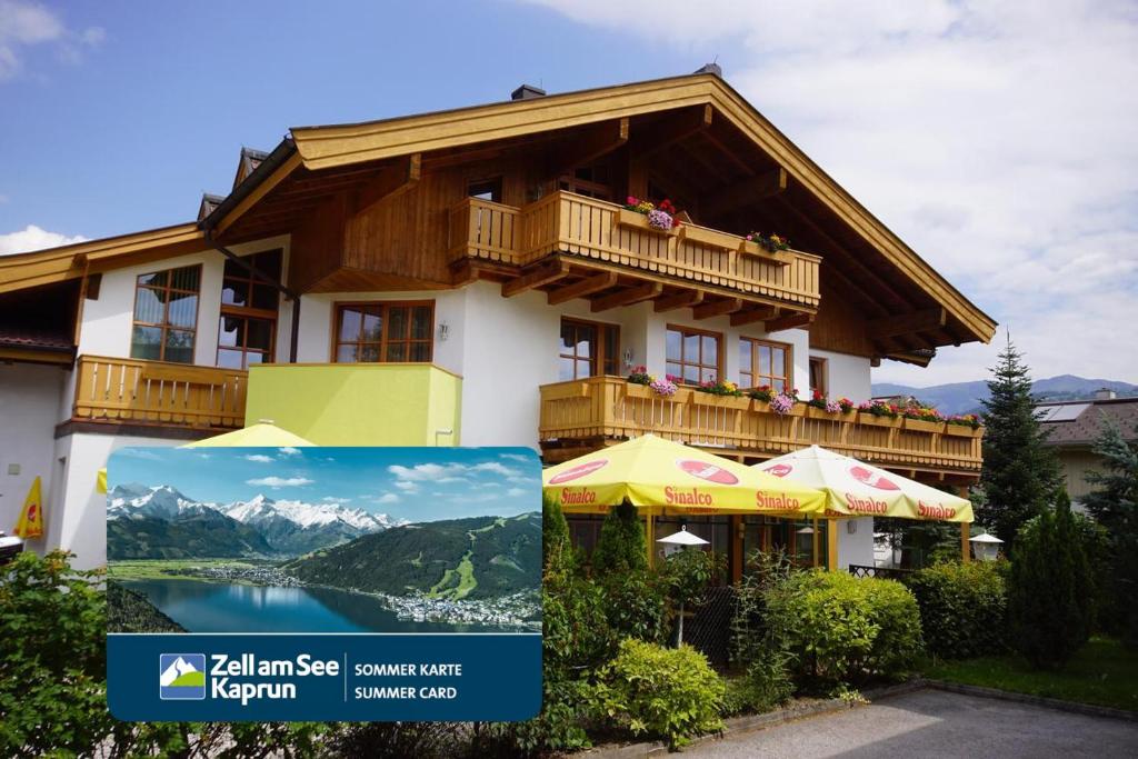 a building with a balcony with a view of a lake at Hotel Landhaus Zell am See in Zell am See