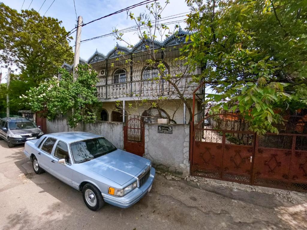 a blue car parked in front of a house at La Vitalie Guest House in Chişinău