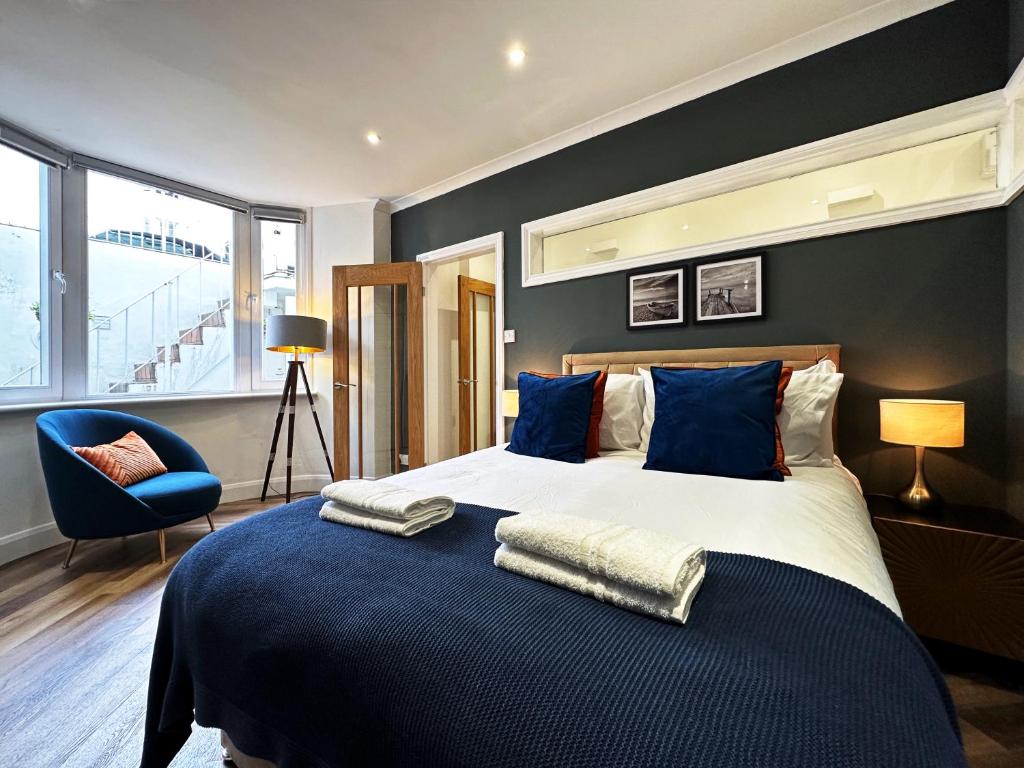 a bedroom with a large bed with blue pillows at Liam's Place near Hyde Park in London