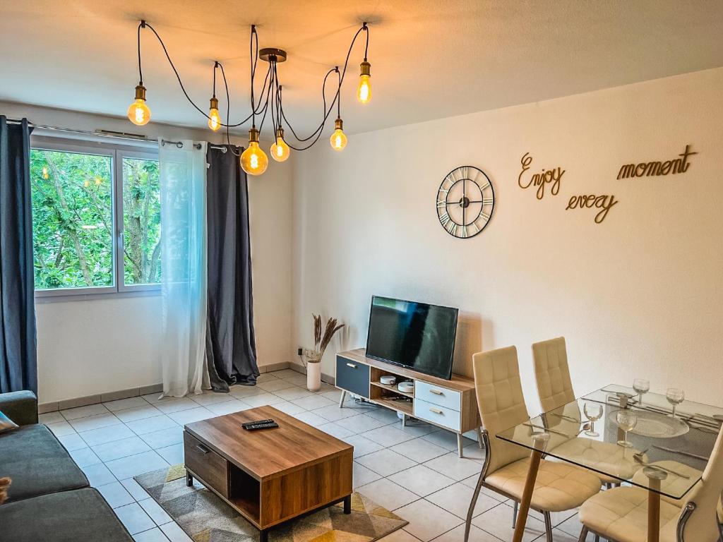 a living room with a table and a tv at Apparthotel - Paradis Médiéval in Poitiers