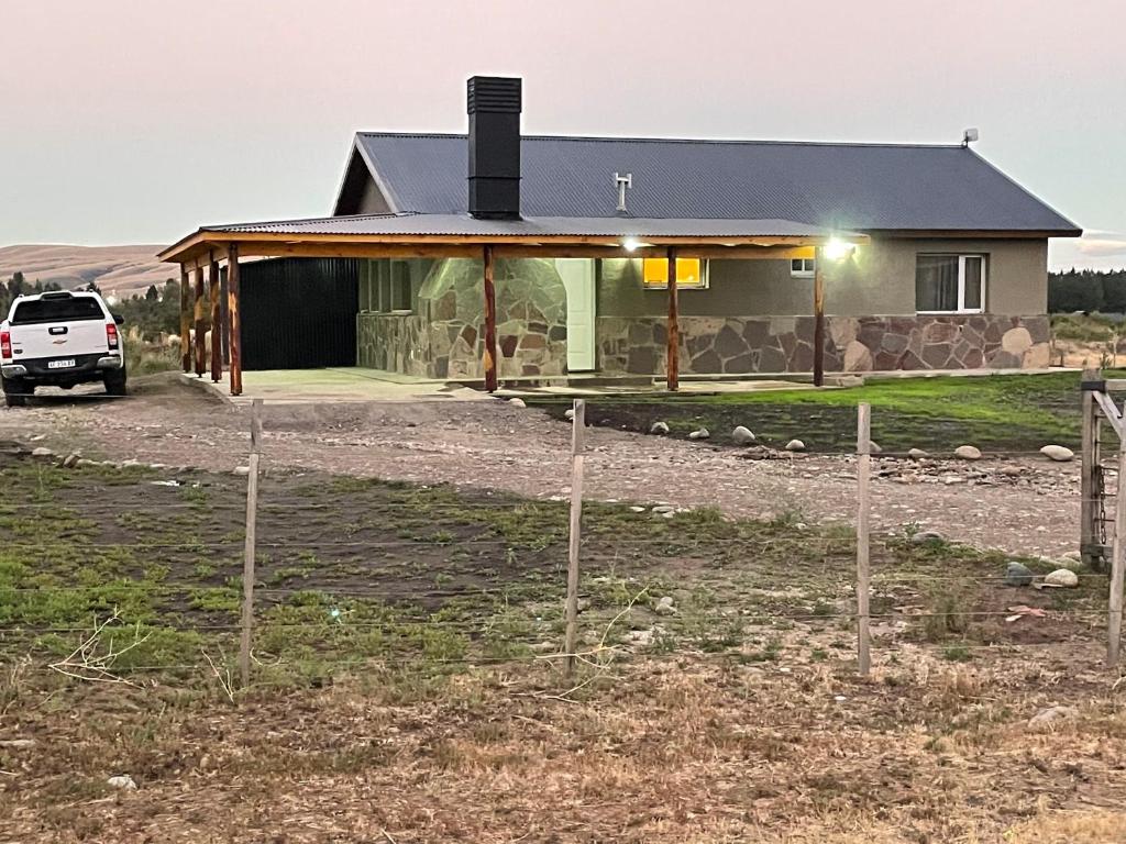 une maison avec une voiture garée devant elle dans l'établissement Casa Las Marías San Martin de Los Andes, à San Martín de los Andes