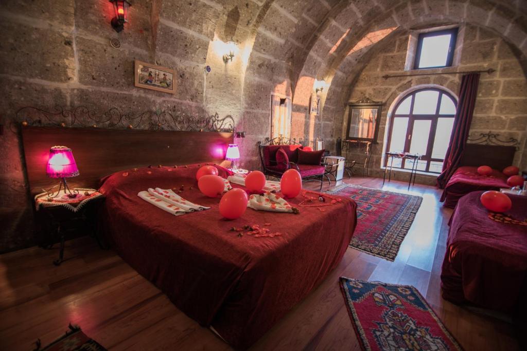 Un dormitorio con una cama con almohadas rojas. en Kapadokya Ihlara Konaklari & Caves en Guzelyurt