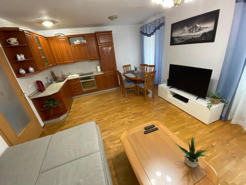 een woonkamer met een televisie en een tafel bij Shadi Apartment in Koper