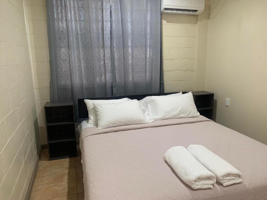 a bedroom with a bed with two towels on it at Samoa Business Apartments 2 in Apia