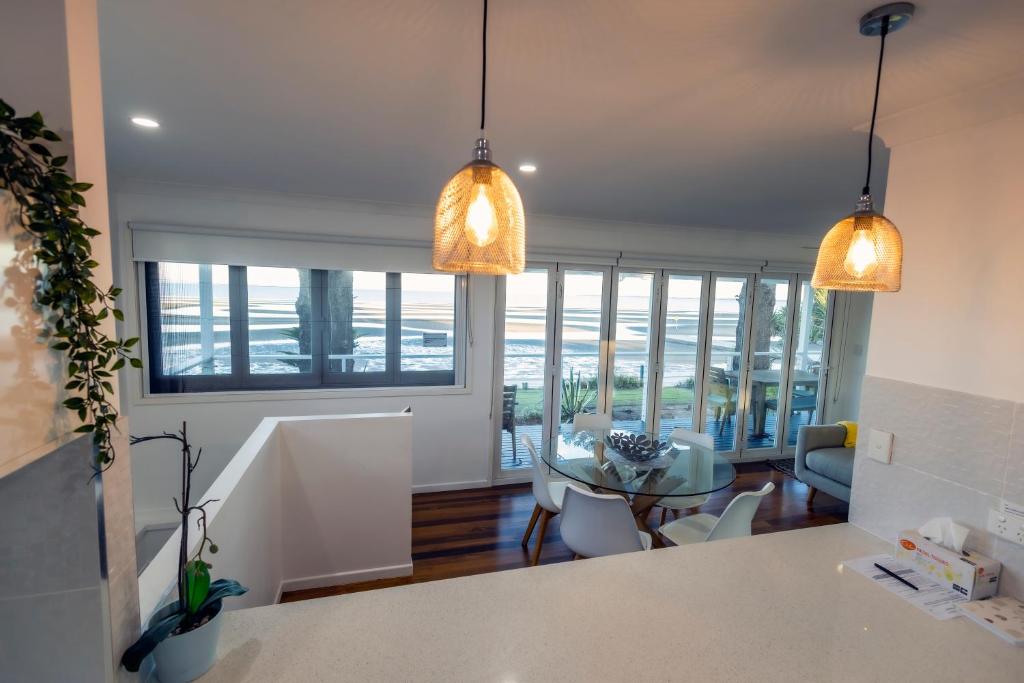a kitchen and living room with two pendant lights at Happy Tides in Beachmere