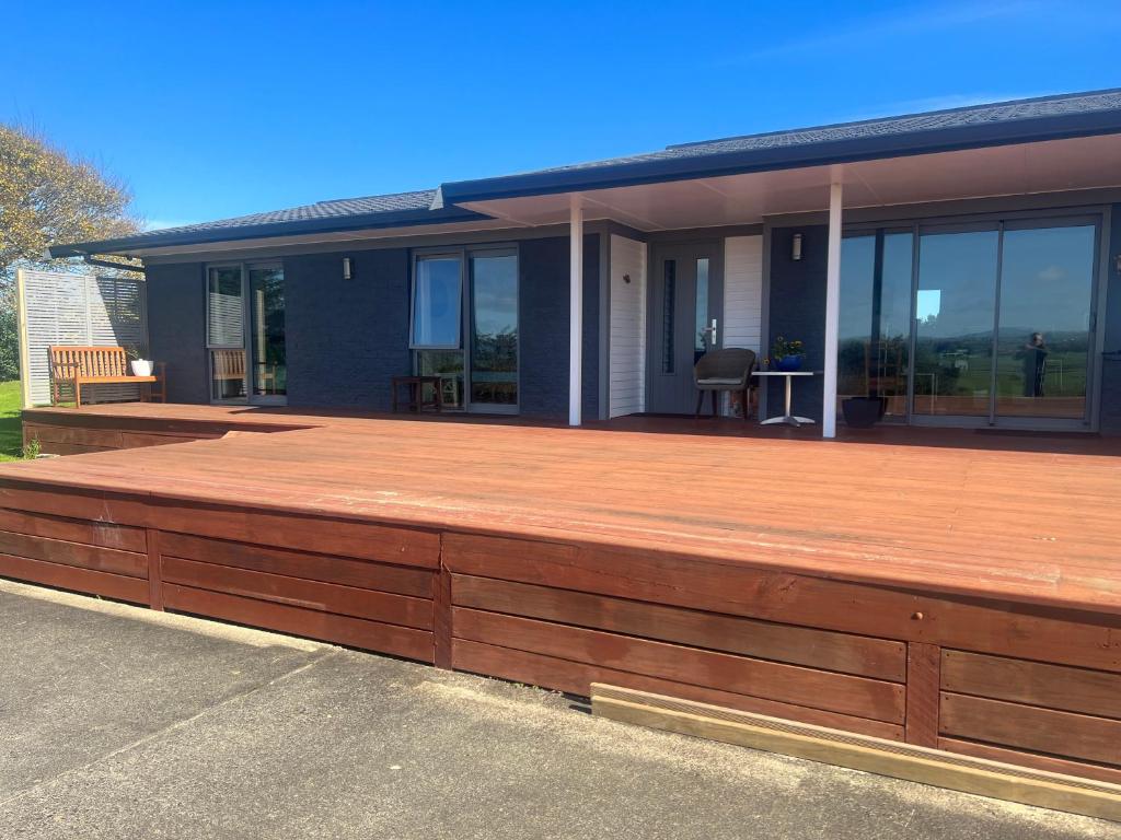 a large wooden deck on the side of a house at Beauty at whitbourne in Otorohanga