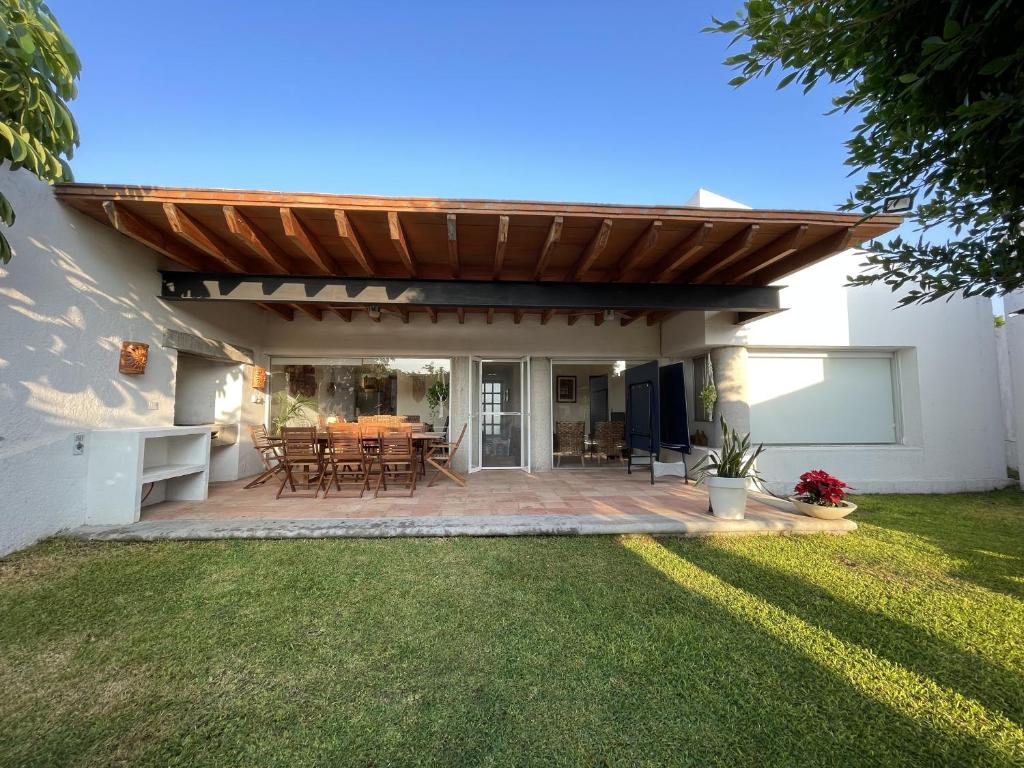 eine Terrasse mit einer hölzernen Pergola und einem Tisch in der Unterkunft Casa Tabachin in Alpuyeca