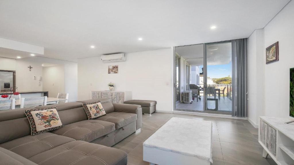 a living room with a couch and a table at Oceans Edge #19 Short Walk To Beach , Shops and Cafes Accom Holidays in Terrigal