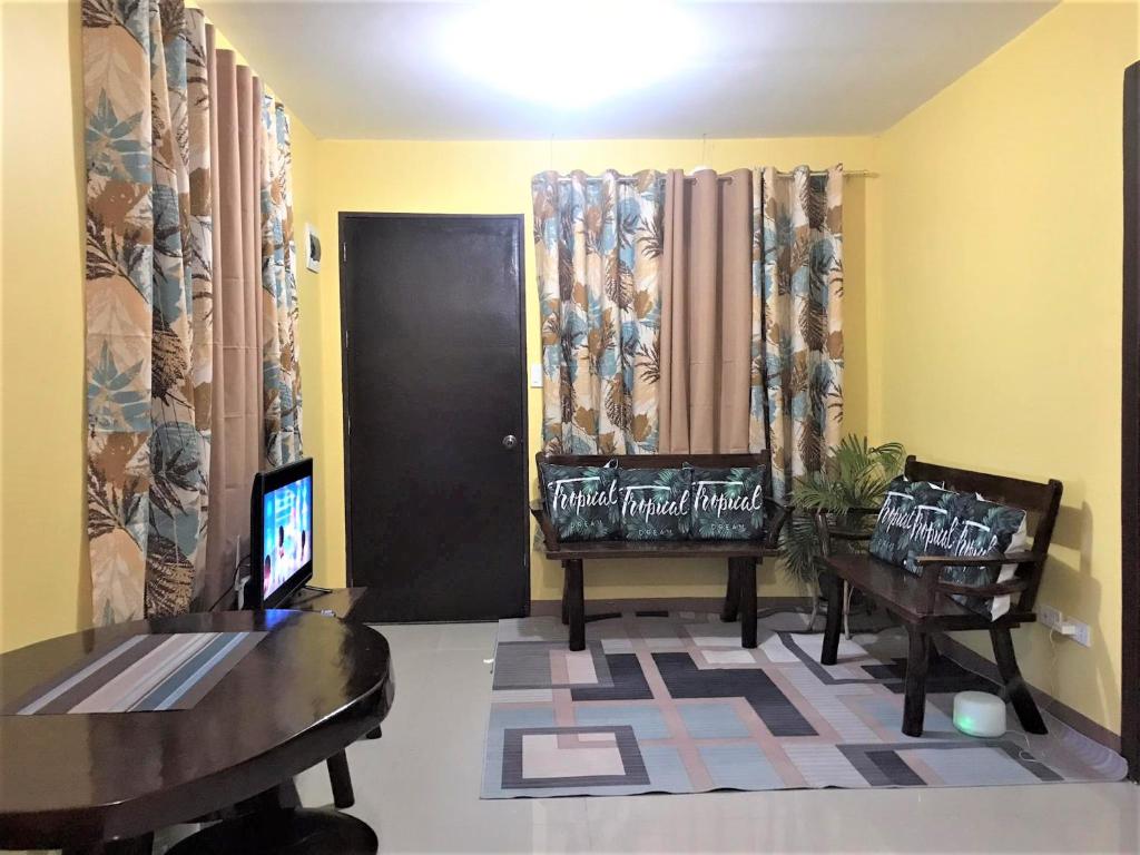 sala de estar con TV, mesa y sillas en Affordable Whole House Rent Transient en Butuán