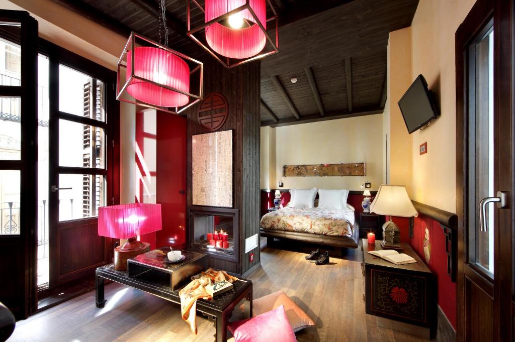a bedroom with a bed with red lamps and a table at Casa Palacete 1822 in Granada