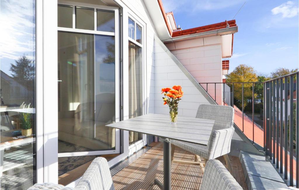 a table on a balcony with a vase of flowers at Baltischer Hof Apartment 50 in Boltenhagen