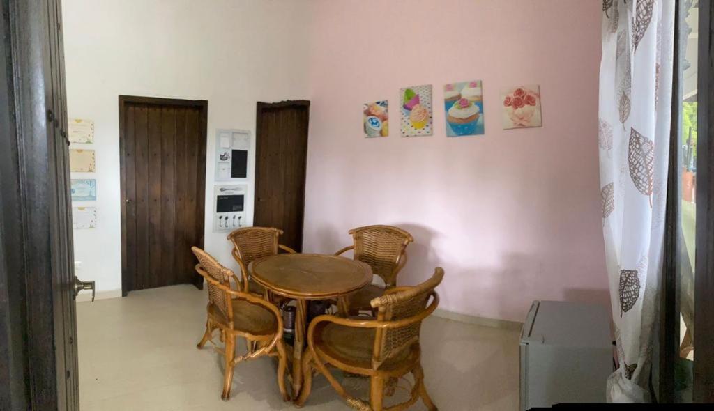 ein Esszimmer mit einem Holztisch und Stühlen in der Unterkunft Habitaciones con Baño privado - Finca Valentina in Anolaima