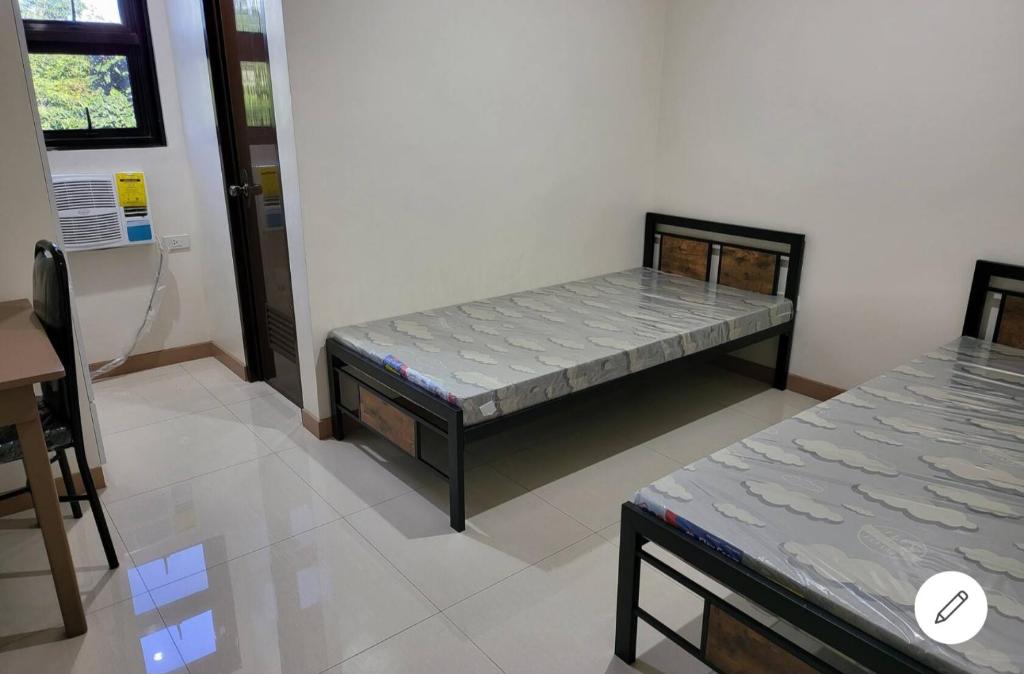 ein Zimmer mit einem Bett in der Ecke eines Zimmers in der Unterkunft Dormitory near SM and S and R in Davao City