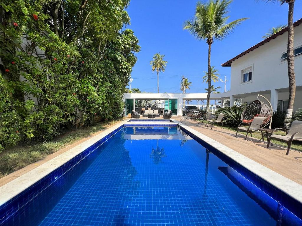 uma piscina num quintal com uma casa em SAL di Mare Hotel Boutique - Frente ao Mar com Piscina no Guarujá