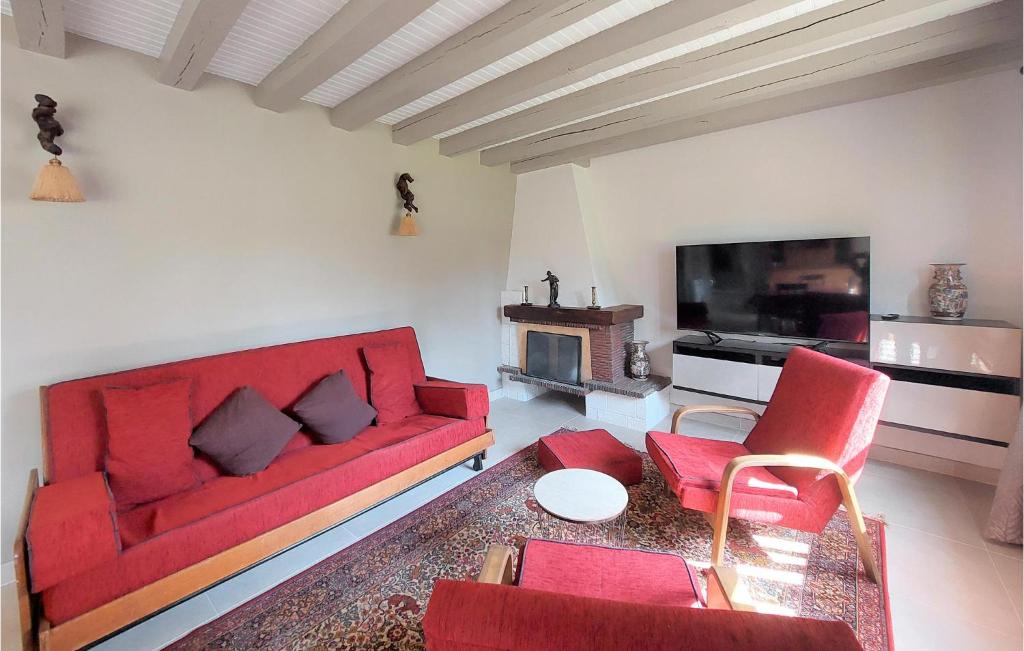 sala de estar con sofá rojo y TV en Nice Home In tigny With Wifi, en Étigny