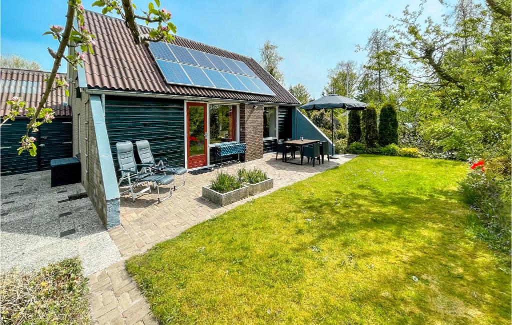 ein Haus mit einer Terrasse mit einem Tisch und Stühlen in der Unterkunft 3 Bedroom Gorgeous Home In Lauwersoog in Lauwersoog