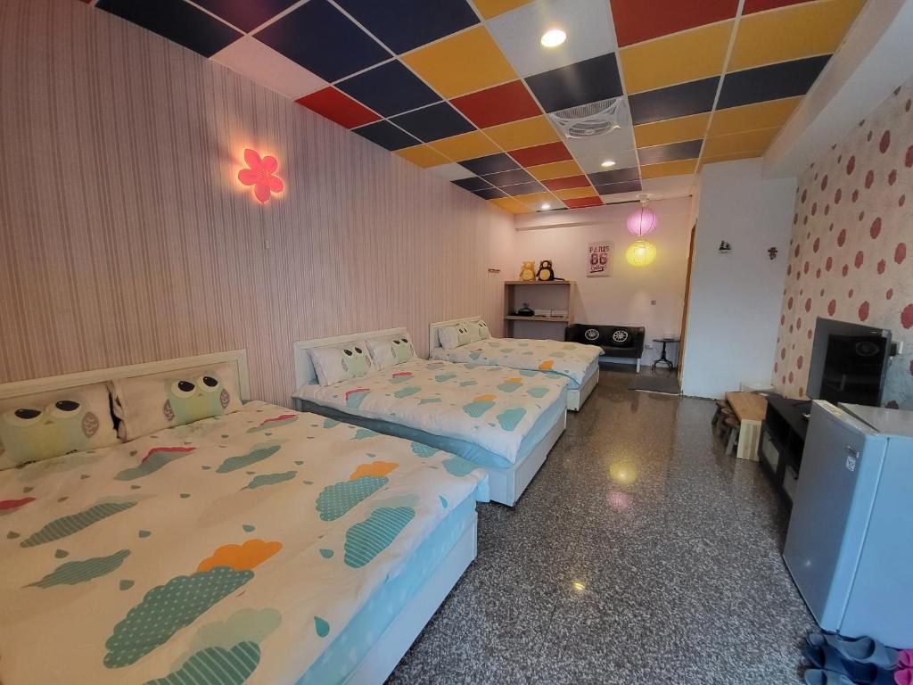 Zimmer mit 2 Betten und einem TV. in der Unterkunft 驛站會館 in Luodong