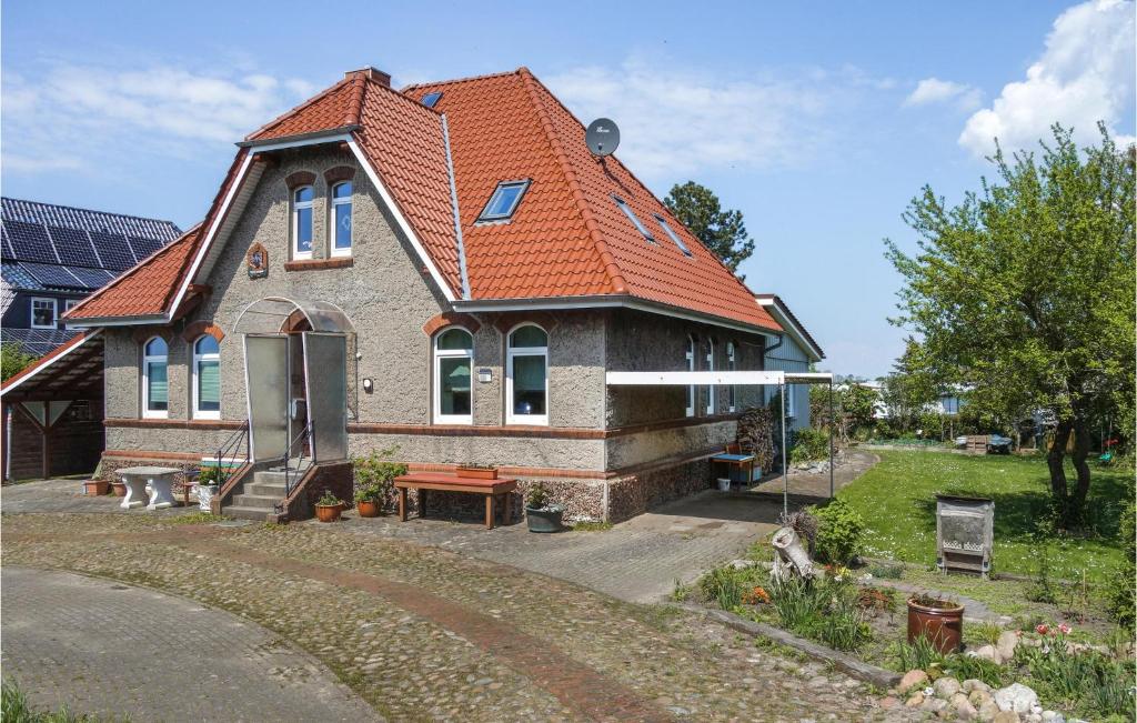 a house with an orange roof on a street at Cozy Apartment In Wurster Nordseekste With Wifi in Hofe