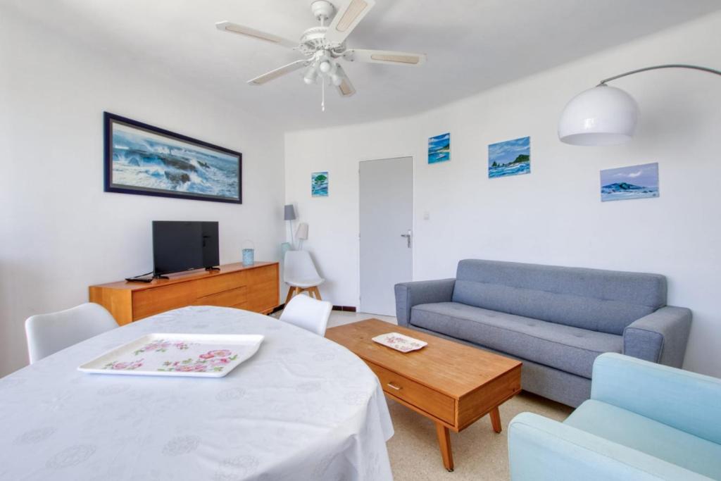 un salon avec un canapé et une table dans l'établissement Bright 60m near the beach, à Six-Fours-les-Plages