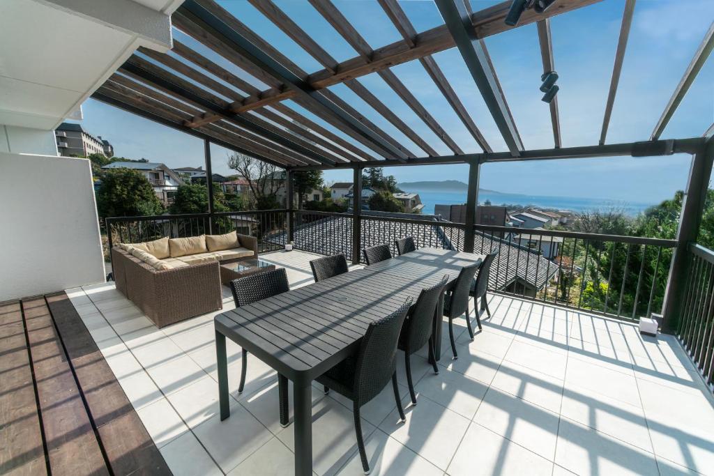 a patio with a table and chairs on a balcony at TenangTenang-Izu Oceanic Villa- in Futo