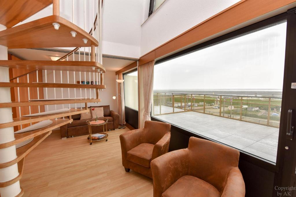 ein Zimmer mit Stühlen und einem großen Fenster mit Balkon in der Unterkunft Haus "Jan am Strand" Appartement JAN504 in Döse