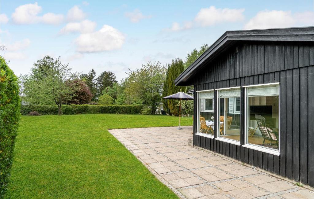 ein schwarzes Haus mit einer Terrasse im Hof in der Unterkunft 2 Bedroom Pet Friendly Home In Hornbk in Hornbæk