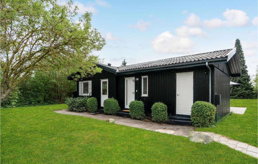 a black house with white doors and a yard at 2 Bedroom Pet Friendly Home In Hornbk in Hornbæk
