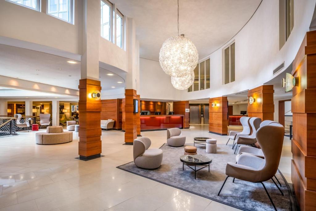 um lobby de um hotel com cadeiras e mesas em Cologne Marriott Hotel em Colônia