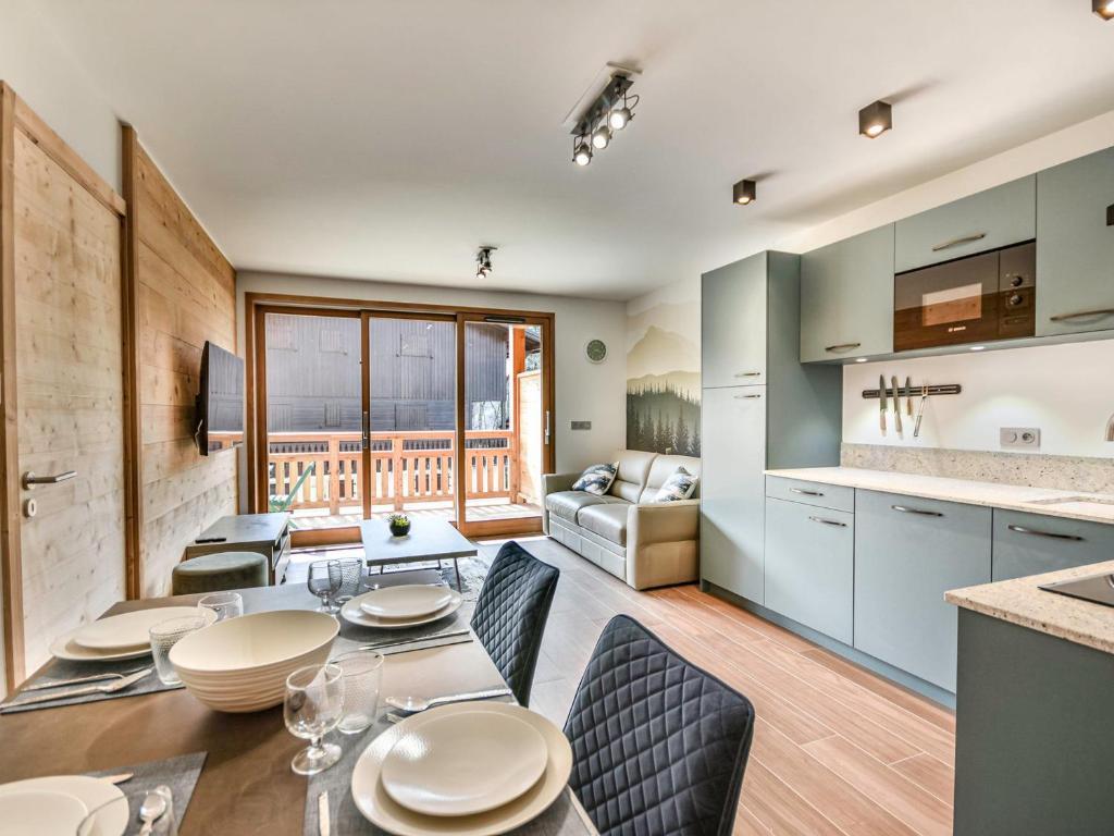 une cuisine et un salon avec une table et des chaises dans l'établissement Le Génépi - Superbe T2 cabine 4-6 pers, neuf, à 50m des pistes, avec balcon, garage et WiFi - FR-1-685-67, aux Gets