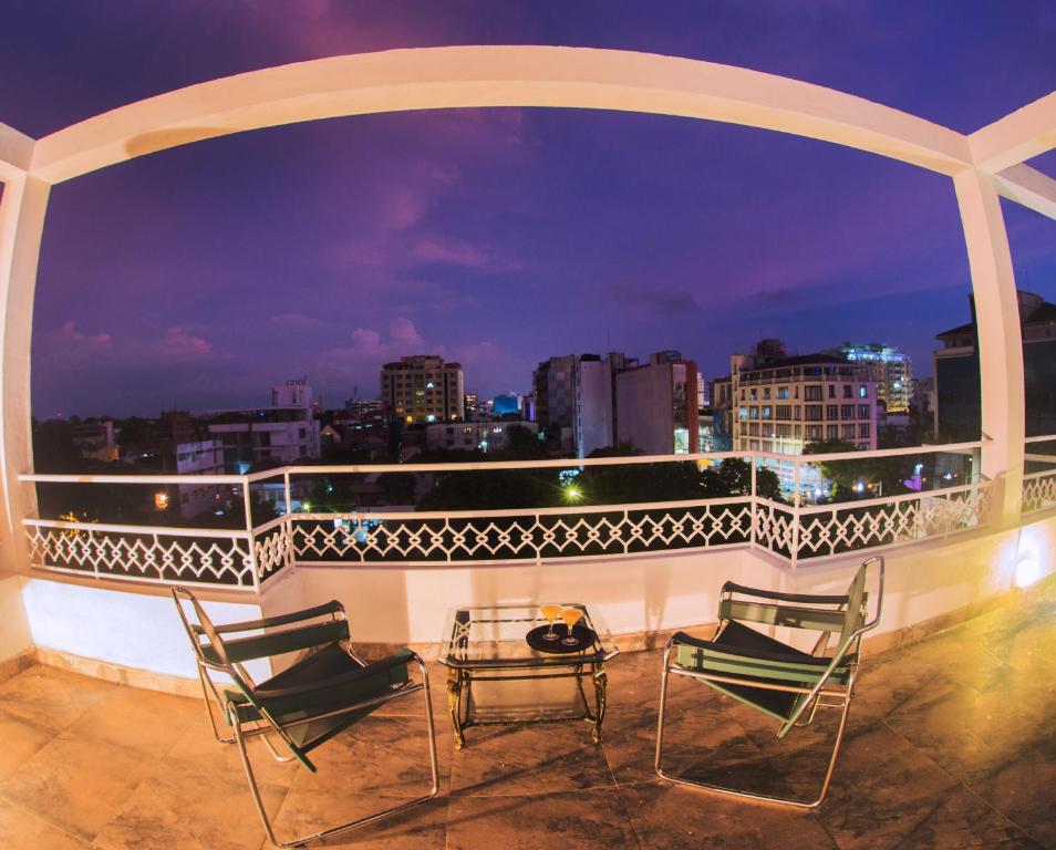 a balcony with chairs and a table and a city skyline at Whitehouse Residencies in Colombo