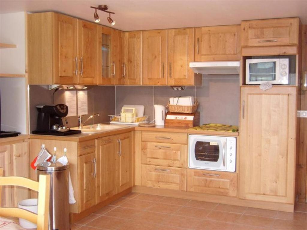 a kitchen with wooden cabinets and white appliances at Appartement Crest-Voland, 2 pièces, 6 personnes - FR-1-733-6 in Crest-Voland
