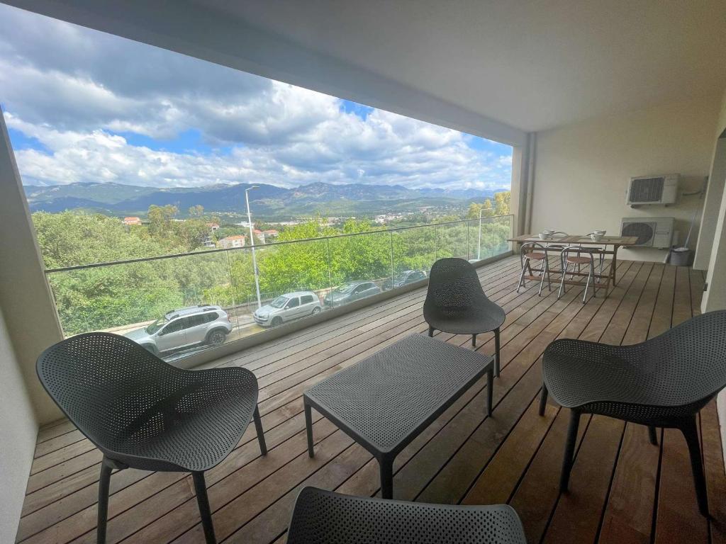 a room with a balcony with chairs and a large window at Appartement Porto-Vecchio, 2 pièces, 4 personnes - FR-1-62-170 in Porto-Vecchio