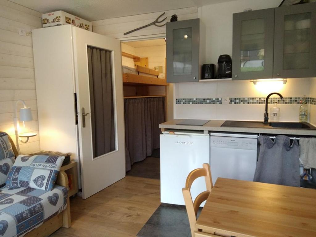 a kitchen and a living room with a table at Studio cosy avec terrasse, équipements complets, parking et casier à skis - Crest-Voland - FR-1-733-118 in Crest-Voland