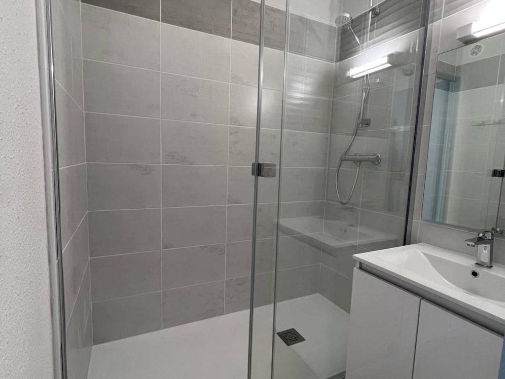 a white bathroom with a shower and a sink at Appartement Le Barcarès, 2 pièces, 4 personnes - FR-1-81-589 in Le Barcarès