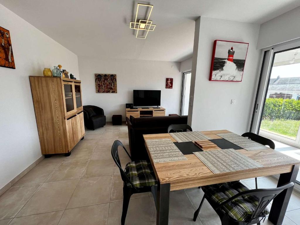 un salon avec une table et des chaises en bois dans l'établissement Appartement 3 pièces rénové, proche plage et côte sauvage avec jardin et parking - Quiberon - FR-1-478-252, à Quiberon