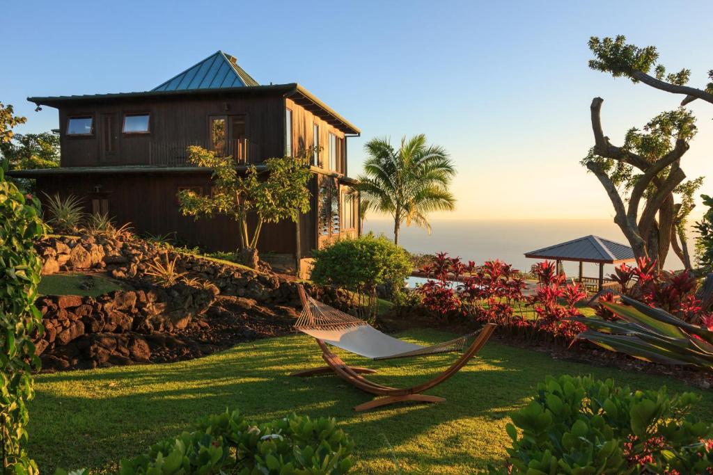 a hammock on the lawn in front of a house at Holualoa Inn in Kailua-Kona