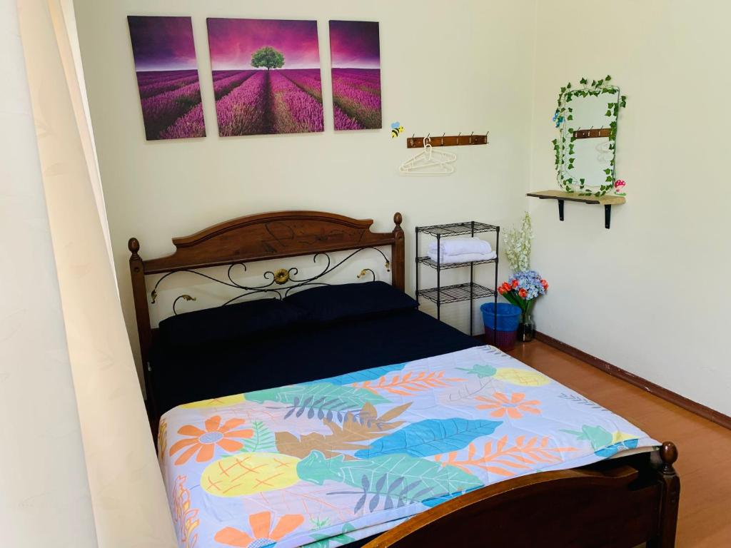 Kampong Bukit KatilにあるBella Homestay Melakaのベッドルーム1室(カラフルな掛け布団付きのベッド1台付)