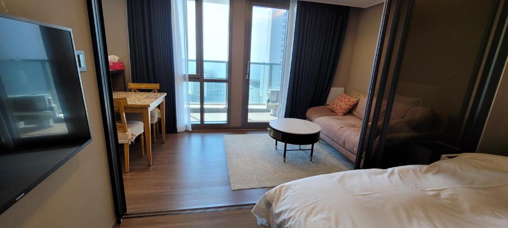 a bedroom with a bed and a desk and a mirror at Flat nearby Heaundae beach in Busan