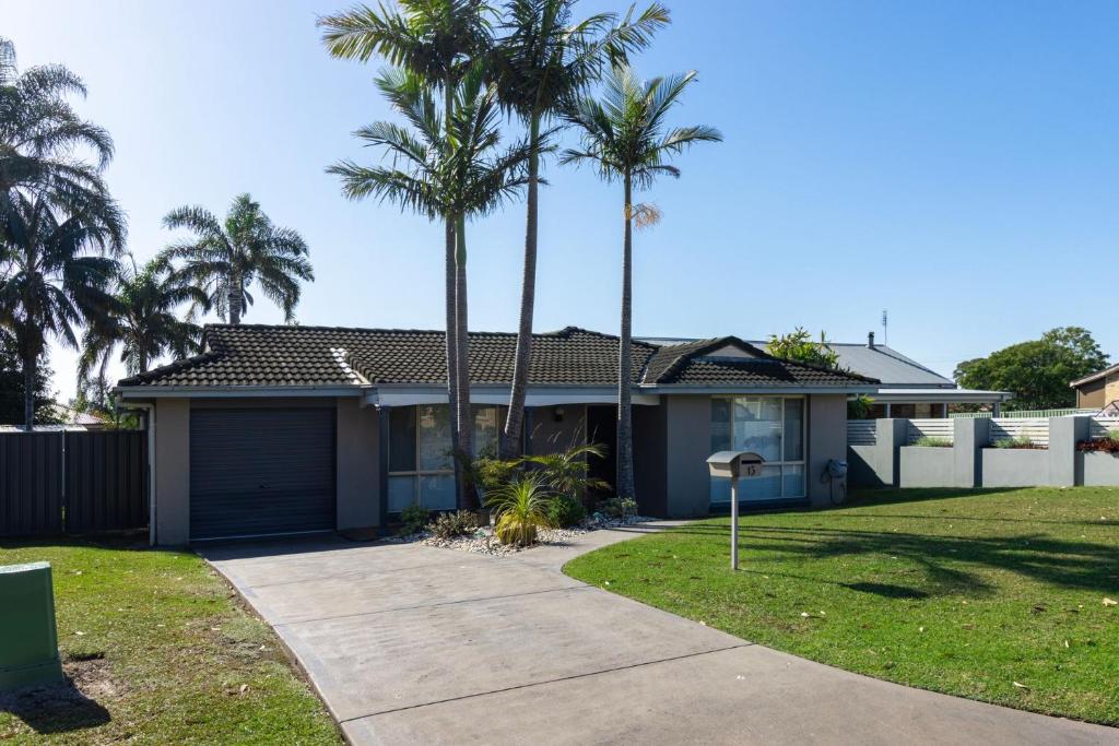 a house with palm trees and a driveway at Peaceful Cul de sac in Sussex inlet