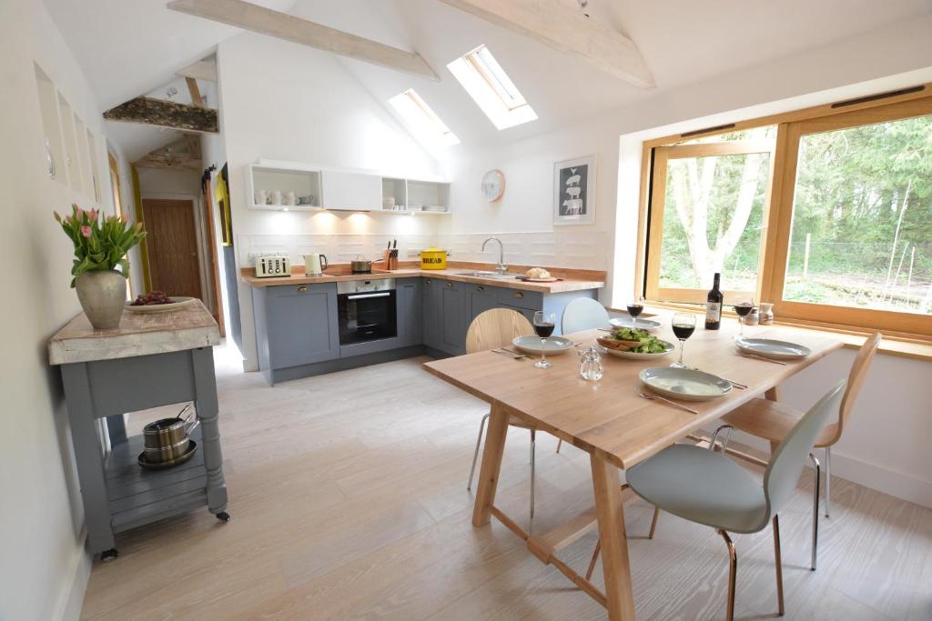 a kitchen and dining room with a table and chairs at Red Poll Barn in Spexhall