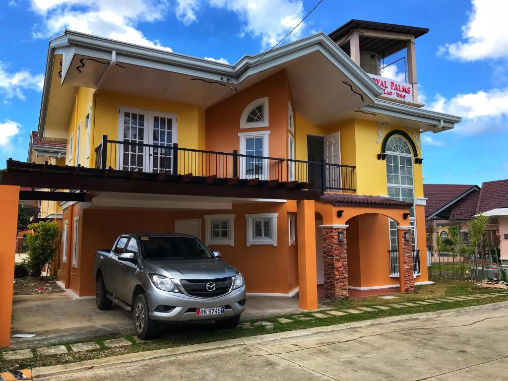 a car parked in front of a yellow house at RPU WEN`S Villa in Dauis
