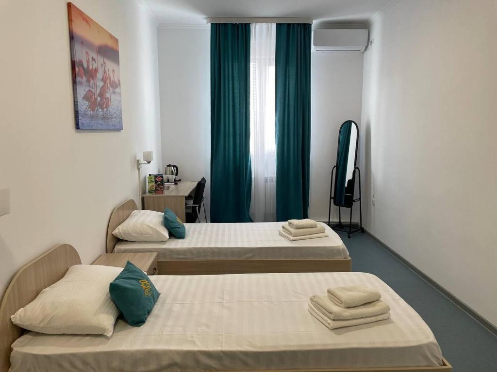 Pokój z 3 łóżkami i telewizorem w obiekcie Apec Hotel w mieście Atyrau